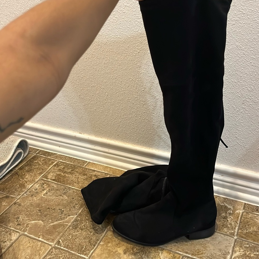 Women’s target size 8 black knee high boots with a string on the back.